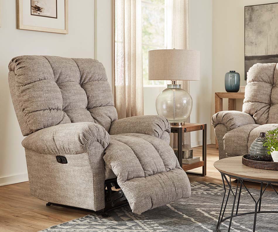 A photo of a tufted tan recliner displays its reclining abilities in a cream colored living room.