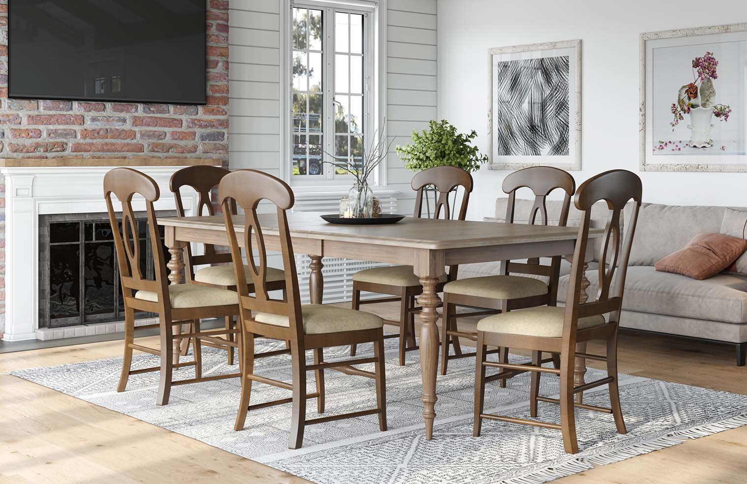A long dining table with decorative legs sits in a farmhouse style dining room with matching chairs.