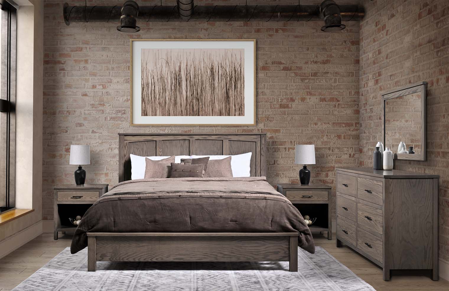 A queen-size bed sits in a brick-walled room with a dusty ash wooden frame, matching side tables, and a six-drawer dresser.