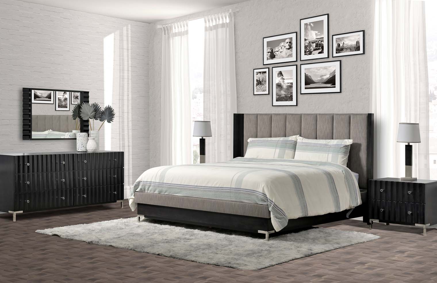 A platform bed frame with black wood and an upholstered grey headboard sits in a grey bedroom with a matching dresser and side tables.