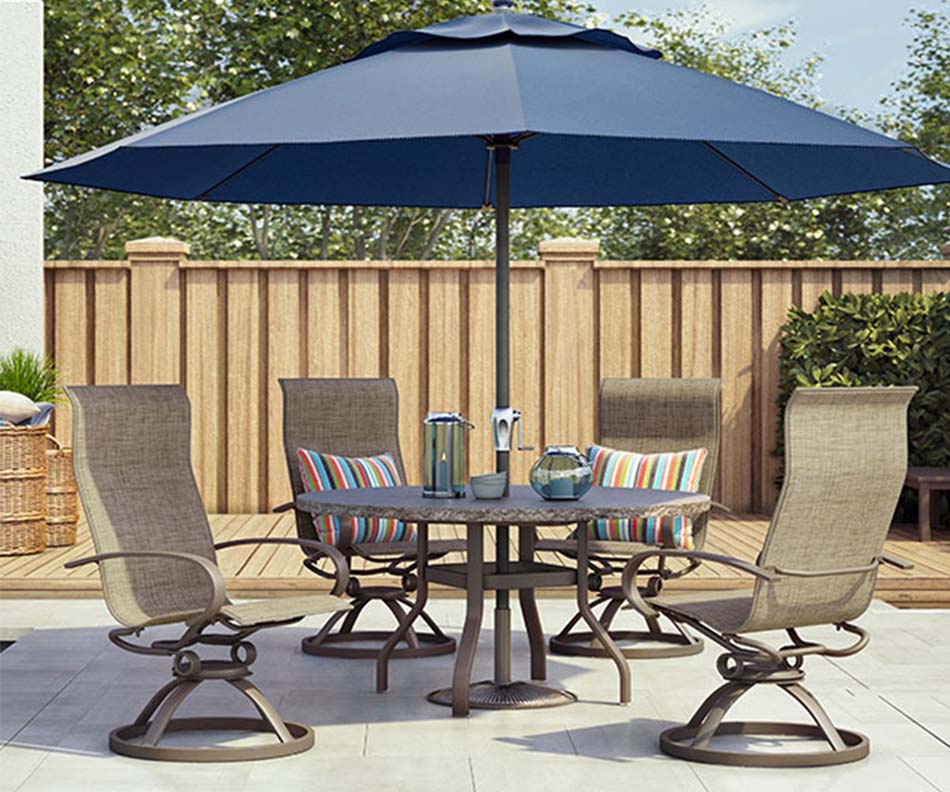 A outdoor patio furniture set with tan high-backed chairs and a large blue umbrella sits outside, displaying the furniture in a patio setting.