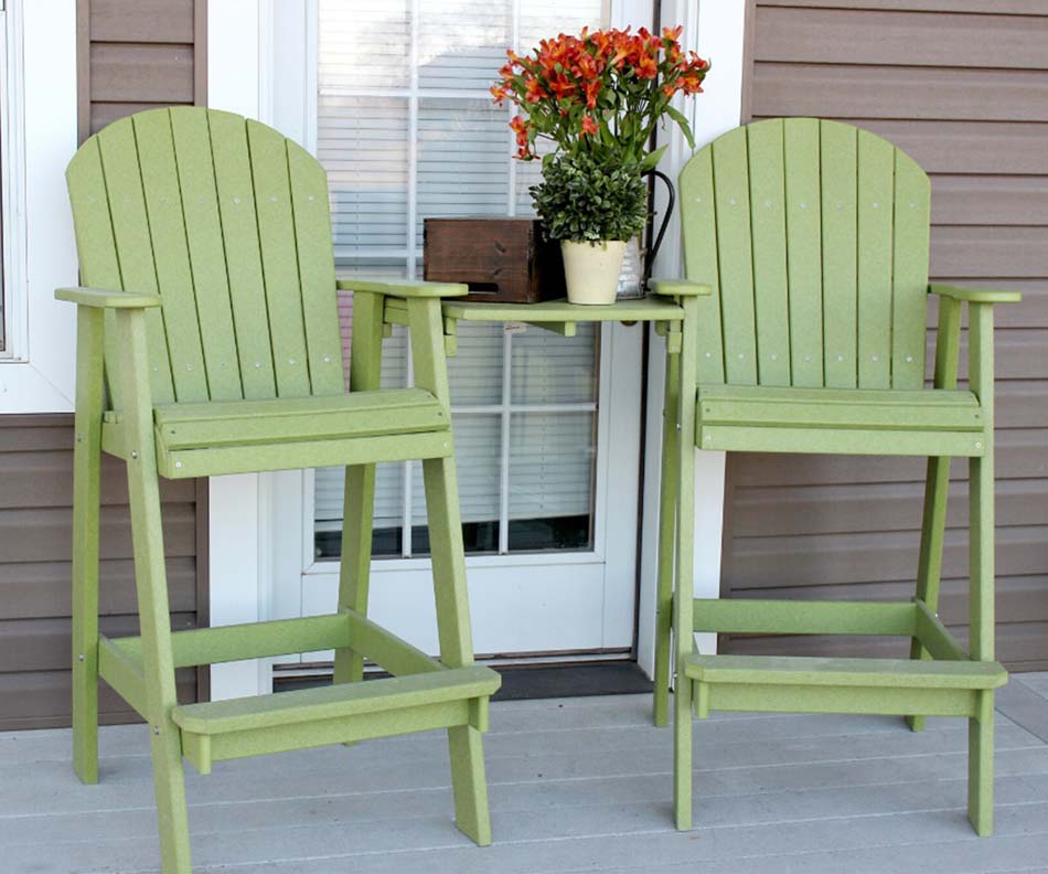 A photo displaying a pair of long legged, green tea colored chairs with a side table hanging between them.