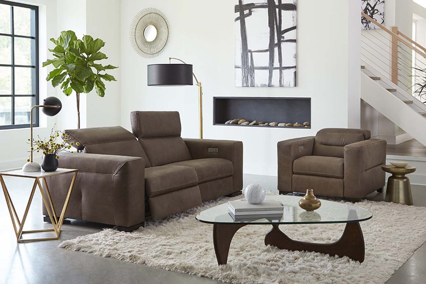 A geometric loveseat and matching style chair are upholstered in a matte, dark taupe leather.