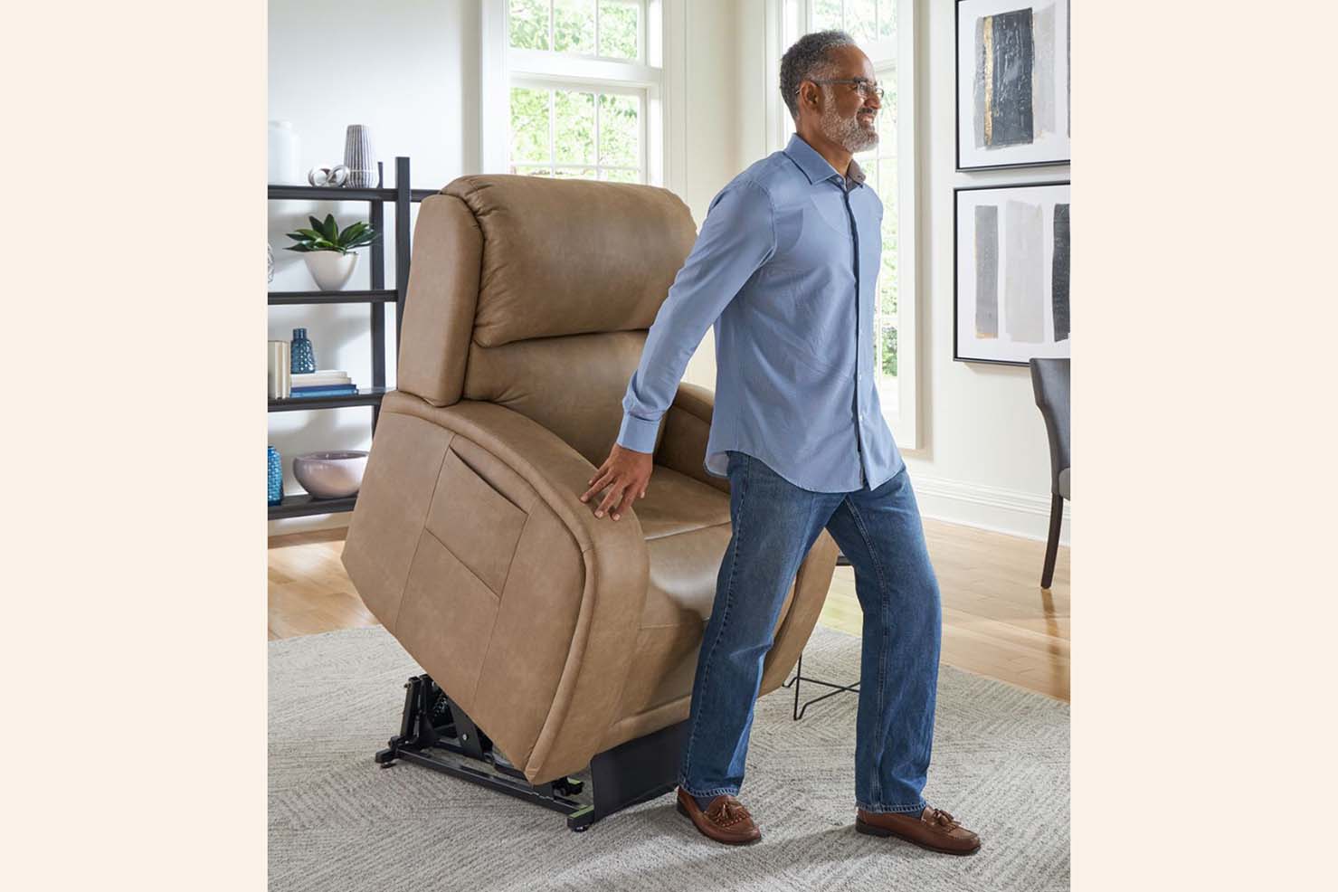 An older man exits a tan power recliner with ease as the power recliner is in an upright position.