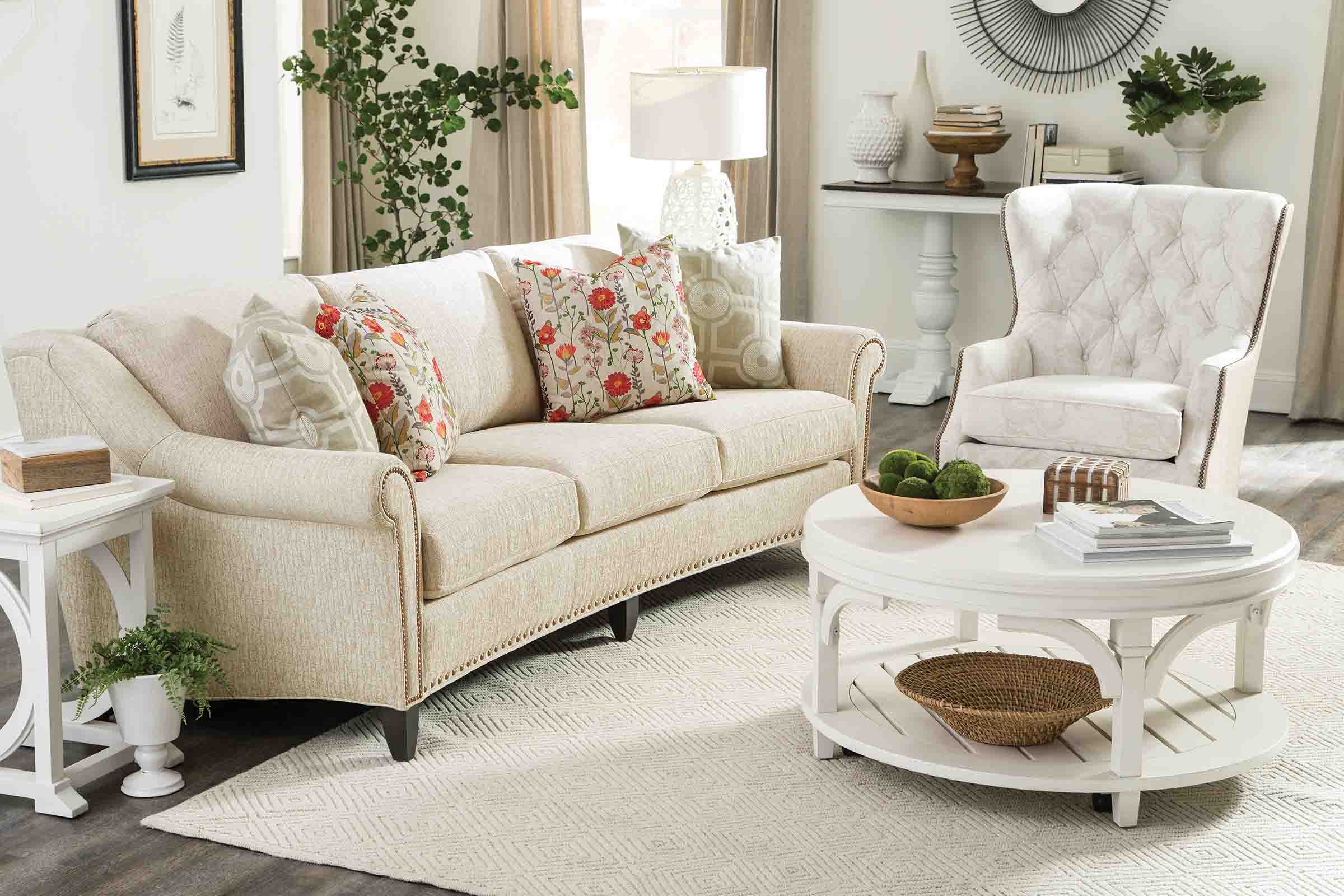 A short sectional with a patterned ottoman is upholstered in a camel-colored leather.